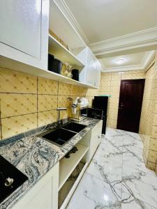 a kitchen with a sink and a counter top at Magnifique Appartement meublé de 2 chambres avec GROUPE ELECTROGENE et ASCENSEUR in Douala