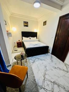 a bedroom with a bed and a marble floor at Magnifique Appartement meublé de 2 chambres avec GROUPE ELECTROGENE et ASCENSEUR in Douala