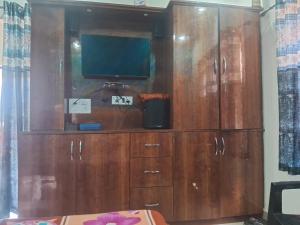 a large wooden cabinet with a television on top at Nilkanth gest hause in Mukteshwar