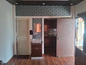 a kitchen with a pink door and a sink at Nilkanth gest hause in Mukteshwar