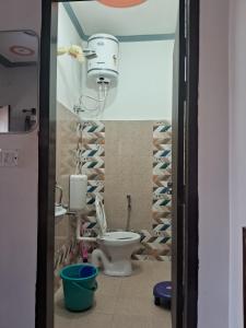 a bathroom with a toilet and a wall of wine bottles at Nilkanth gest hause in Mukteshwar +28 photos
