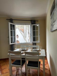 a dining room table with two chairs and a window at Machico Village Apartment - Private terrace & car park in Machico