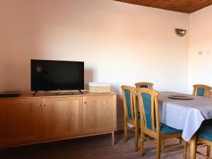 a dining room with a table and a television on a cabinet at brown bear lodge in Žabljak