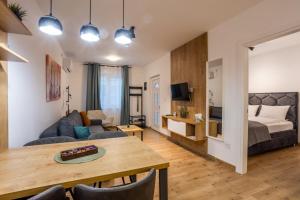 a living room with a couch and a bed and a table at Surčin Central Stay in Surčin