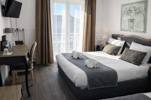 a bedroom with a bed with a desk and a window at Logis Hôtel Blue Garden in Grandvillers