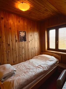 a bedroom with a bed in a wooden cabin at brown bear lodge in Žabljak