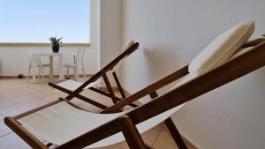 two wooden chairs sitting in a room with a table at Pabula Vernatica Salento in San Pietro Vernotico