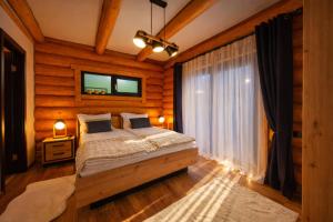 a bedroom with a bed in a room with wooden walls at Căsuța Melimi cu piscină încălzită, ciubăr și saună in Râșca +80 photos