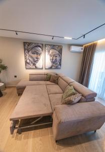 a living room with a couch and three pictures on the wall at Olive Home in Alexandroupoli