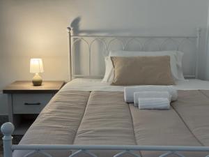 a bed with two pillows and a lamp on a table at Appartamento familiare in centro a due passi dai trulli - Casa Costanza in Alberobello