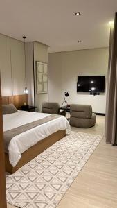 a bedroom with a large bed and a flat screen tv at اصيلة فيلا Asilah Villa in Buraydah