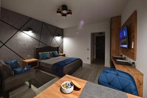 a hotel room with a bed and a couch and a television at Lili's Studio 2 in Piteşti