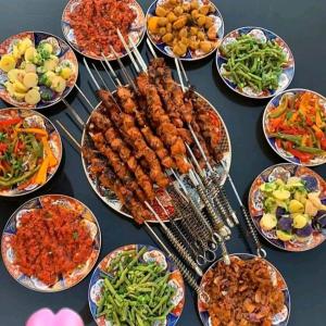 a table full of plates of food with skewers of food at dar elkarzabi in Zagora