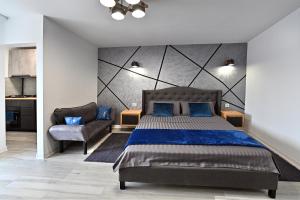 a bedroom with a king sized bed and a chair at Lili's Studio 2 in Piteşti