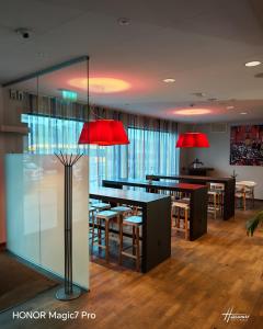 ein Restaurant mit Tischen, Stühlen und roten Lampen in der Unterkunft Tellus Apartment in Lund + 3 Fotos
