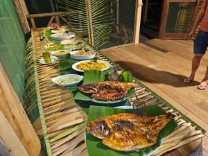 a long table with plates of food on leaves at Paroá Amazon Lodge in Manacapuru