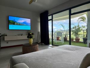 a bedroom with a bed and a flat screen tv at Your Tahiti Escape in Faaa +21 photos