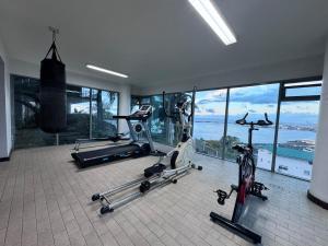 a gym with three exercise bikes in a room with windows at Your Tahiti Escape in Faaa