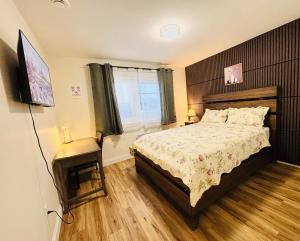a bedroom with a bed and a flat screen tv at New Guesthouse in Charlottetown