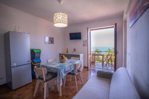 a kitchen and dining room with a table and a refrigerator at Villa Acquamarina, Family apartments with pool - 300 meters from the beach in Santa Maria