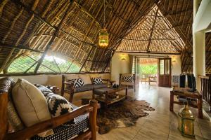 a large living room with a large straw roof at Villa Kapungu with private C h e f, XXL pool & garden in Diani Beach