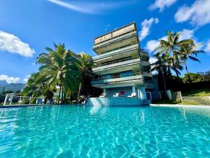a swimming pool in front of a building at Your Tahiti Escape in Faaa