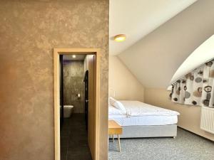a bedroom with a bed and a bathroom at Hotel U Vlašského Dvora in Kutná Hora