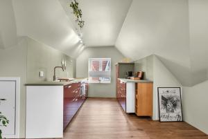 an attic kitchen with a sink and a counter at Central Top Floor Apartment in Stavanger