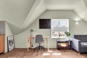 an attic room with a desk and a couch at Central Top Floor Apartment in Stavanger