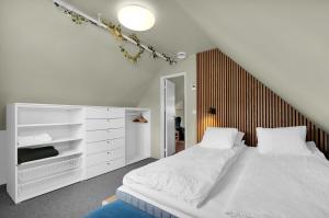 a bedroom with a white bed with a wooden headboard at Central Top Floor Apartment in Stavanger