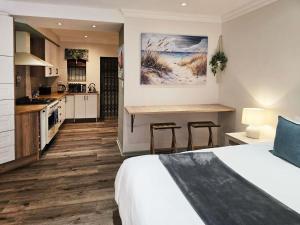 a hotel room with a bed and a kitchen at Breathe Inn in George