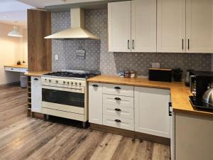a kitchen with white cabinets and a stove top oven at Breathe Inn in George +20 photos