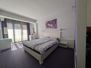 a bedroom with a bed and a large window at Violet Stay in Skopje