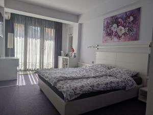a bedroom with a bed and a painting on the wall at Violet Stay in Skopje
