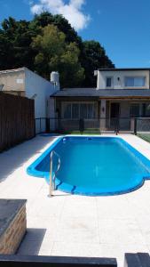a large blue swimming pool in front of a house at Apart Los Tilos 4 pax in Chascomús
