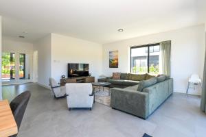 a living room with a couch and a tv at Maan Nr. 301 | 10 Pers. Hottub in Zeewolde