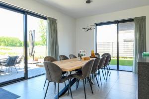 a dining room with a wooden table and chairs at Maan Nr. 301 | 10 Pers. Hottub in Zeewolde