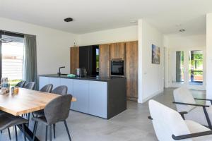 a kitchen and dining room with a table and chairs at Maan Nr. 301 | 10 Pers. Hottub in Zeewolde