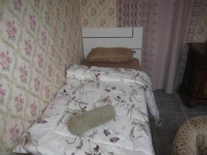 a small bedroom with a bed with a blanket at العين الهيلي مصباح ب 5 in Al Ain