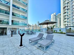 a patio with chairs and an umbrella on a building at Apartamento Special For You in Cartagena de Indias
