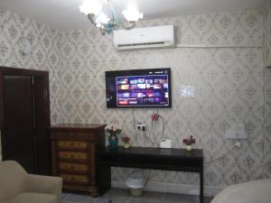 a living room with a television on a wall at العين الهيلي مصباح ب 5 in Al Ain