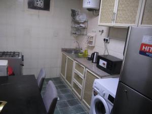 a small kitchen with a table and a refrigerator at العين الهيلي مصباح ب 5 in Al Ain
