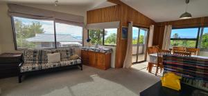 a living room with a couch and some windows at Cagou's Bach in Kuratau