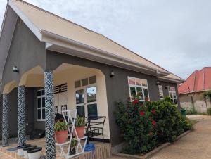 a house with chairs and plants in front of it at Esther & Hans Homes in Dodoma