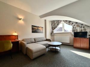 a living room with a couch and a table at Hotel U Vlašského Dvora in Kutná Hora