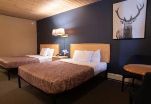 a hotel room with two beds and a deer on the wall at EasyStay Inn & Suites Fernie in Fernie