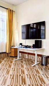 a white desk with a large monitor on the wall at Esther & Hans Homes in Dodoma