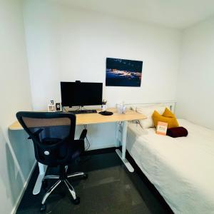 a desk with a computer and a chair next to a bed at Casa de Burgh in Turner