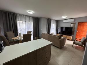 a living room with a couch and a tv at Kheniyas Haven in Nelspruit