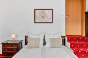 a bed with white sheets and pillows next to a table at Scharnhäusle 15 - Guest room Ostfildern in Ostfildern